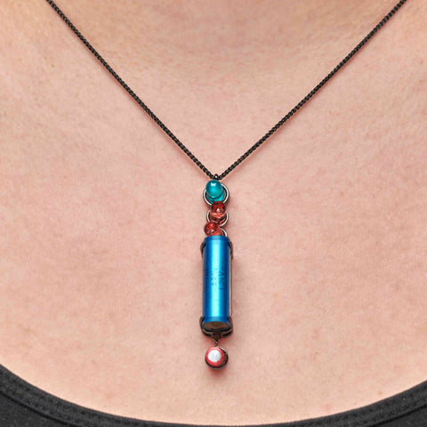 Necklace with a blue cylindrical pendant on a person's neck