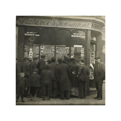A crowd gathered around an East End newsagents window display c.1900