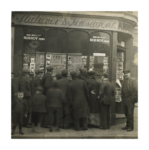 A crowd gathered around an East End newsagents window display c.1900