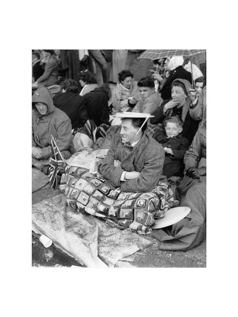 Spectators waiting on the pavement for Queen Elizabeth II's Coronation 1953