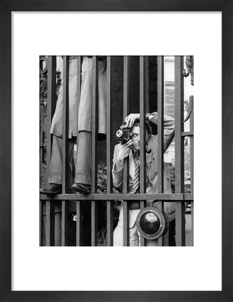 A photographer takes a picture through the railings at Admiralty Arch 1953