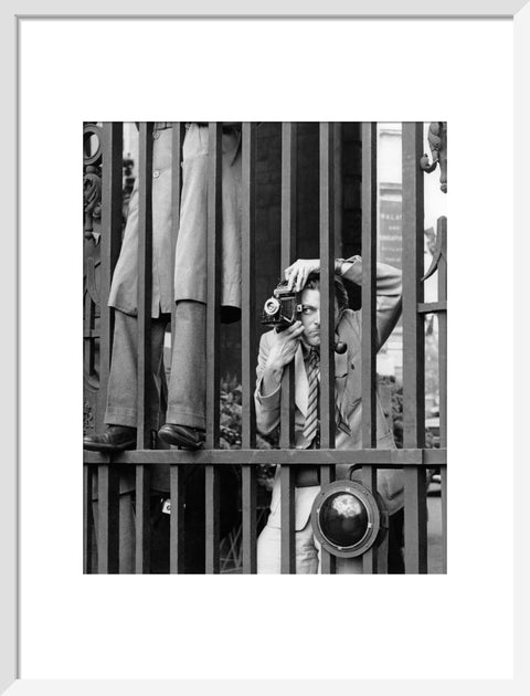 A photographer takes a picture through the railings at Admiralty Arch 1953