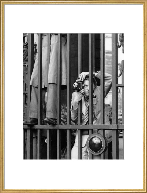 A photographer takes a picture through the railings at Admiralty Arch 1953