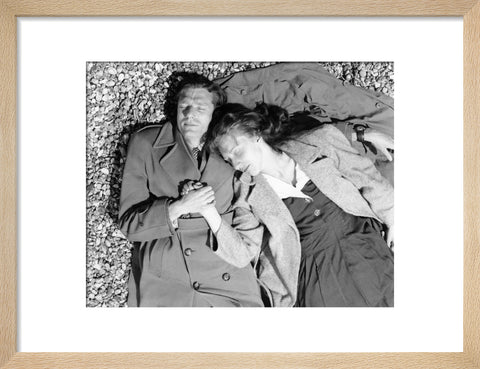 A couple lying together on Brighton Beach c. 1955