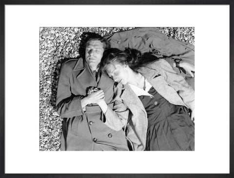 A couple lying together on Brighton Beach c. 1955