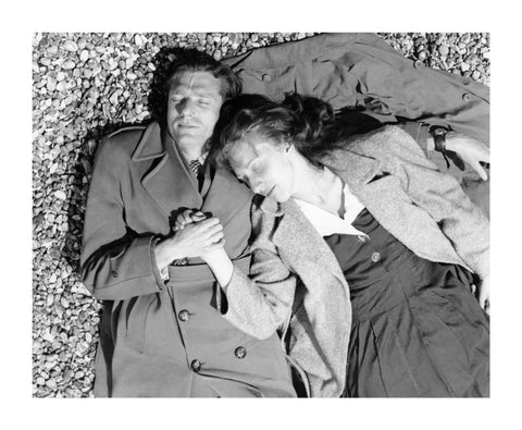A couple lying together on Brighton Beach c. 1955