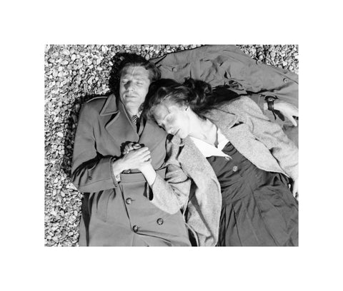 A couple lying together on Brighton Beach c. 1955