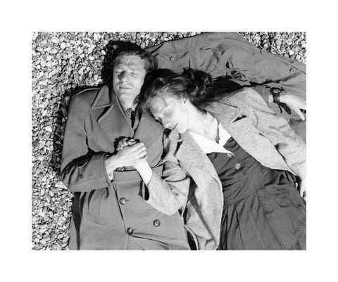 A couple lying together on Brighton Beach c. 1955