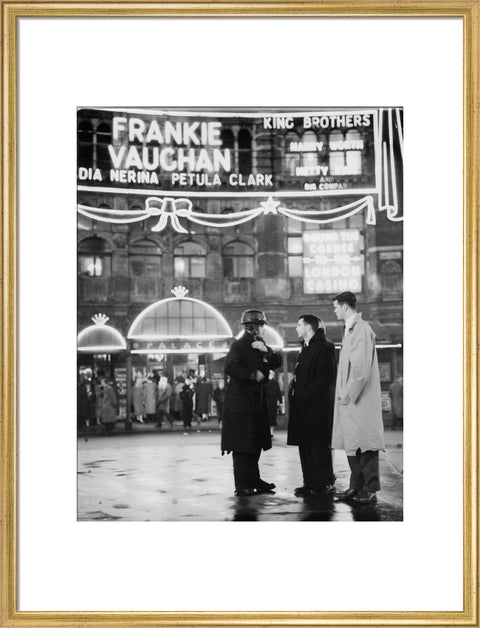 A group of men talking outside the Palace Theatre Shaftsbury Avenue c. 1955
