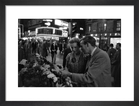 Man buying a woman a flower in the West End 1960