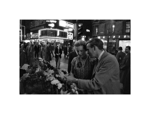 Man buying a woman a flower in the West End 1960