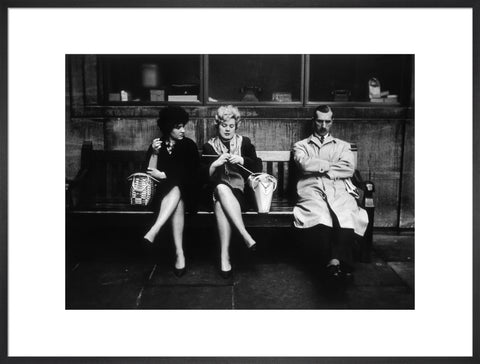 Two women and a man sit on a bench 1961