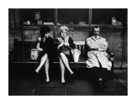 Two women and a man sit on a bench 1961