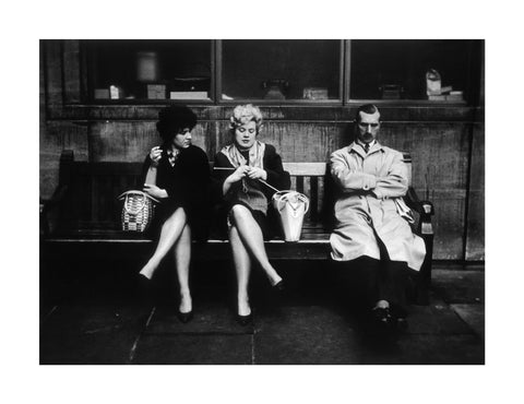 Two women and a man sit on a bench 1961