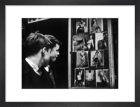 Two boys gazing at images of semi-nude women 1961