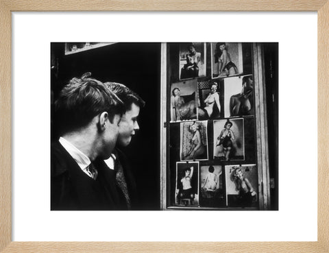 Two boys gazing at images of semi-nude women 1961