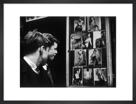 Two boys gazing at images of semi-nude women 1961