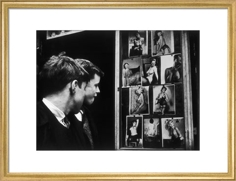 Two boys gazing at images of semi-nude women 1961