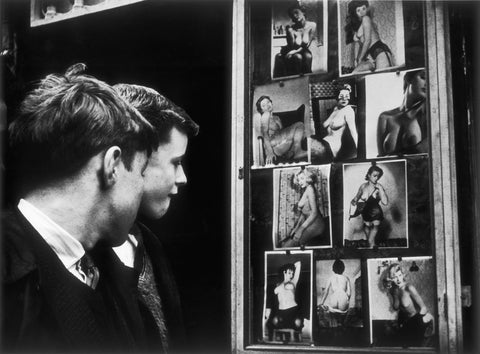 Two boys gazing at images of semi-nude women 1961