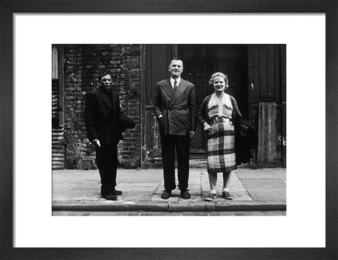 Three people stand on street facing the camera 1961