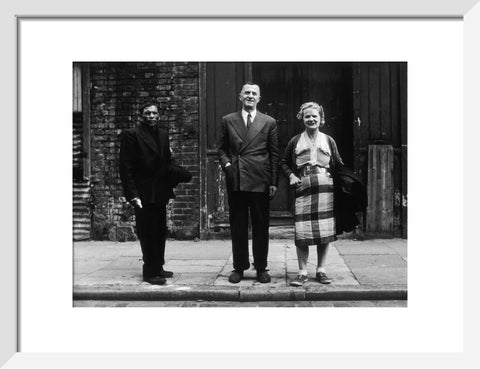 Three people stand on street facing the camera 1961