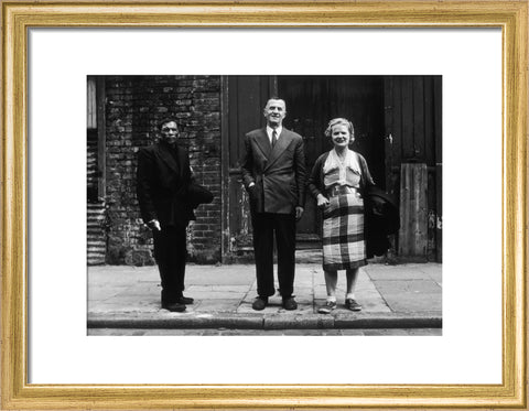 Three people stand on street facing the camera 1961