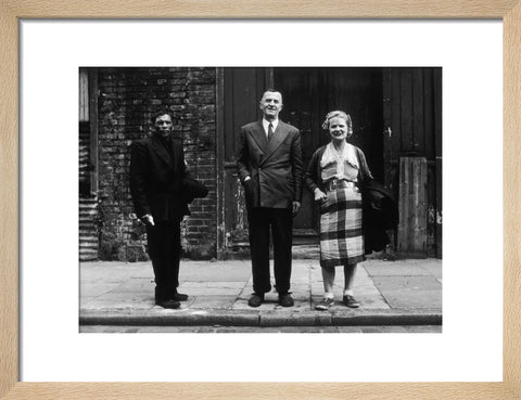 Three people stand on street facing the camera 1961