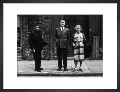 Three people stand on street facing the camera 1961