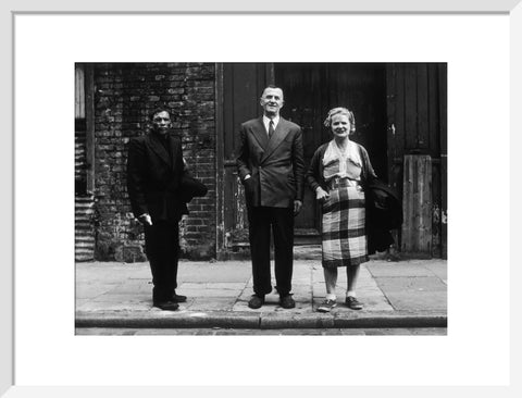 Three people stand on street facing the camera 1961