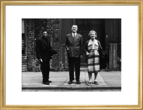 Three people stand on street facing the camera 1961