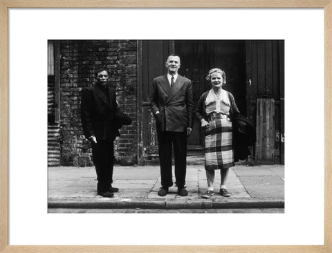 Three people stand on street facing the camera 1961