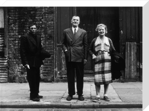 Three people stand on street facing the camera 1961