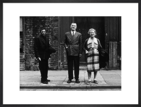 Three people stand on street facing the camera 1961