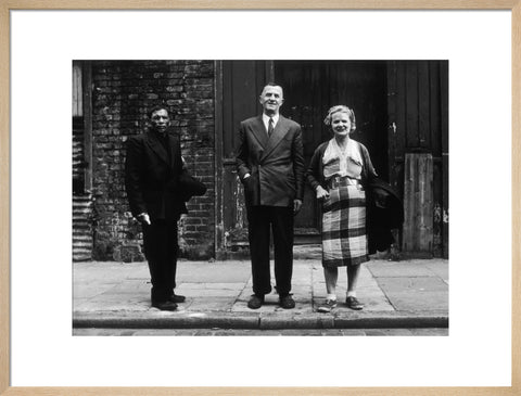 Three people stand on street facing the camera 1961