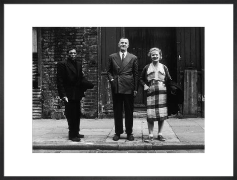 Three people stand on street facing the camera 1961