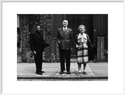 Three people stand on street facing the camera 1961