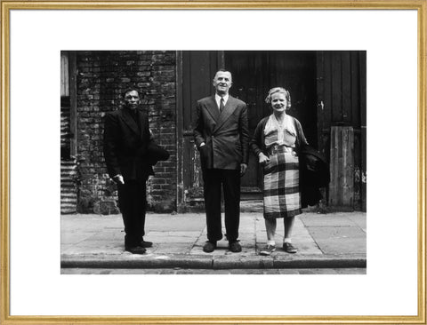 Three people stand on street facing the camera 1961