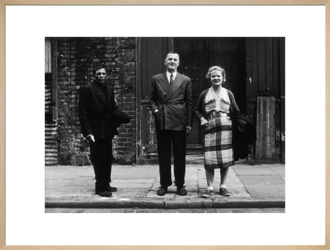 Three people stand on street facing the camera 1961