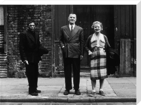 Three people stand on street facing the camera 1961