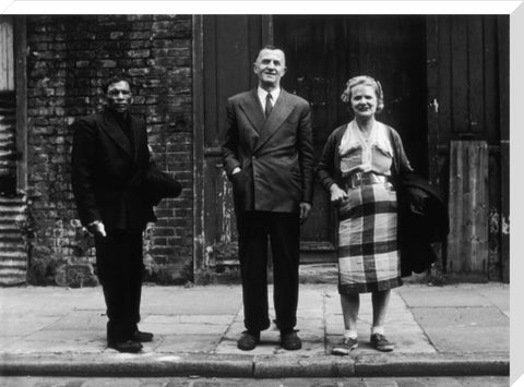 Three people stand on street facing the camera 1961