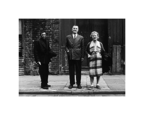 Three people stand on street facing the camera 1961