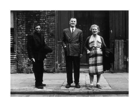 Three people stand on street facing the camera 1961