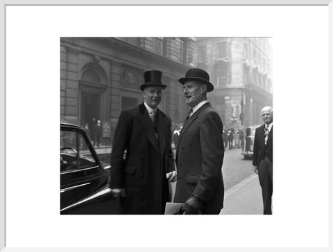 Three formally dressed men on a street flanked by high buildings. c.1955