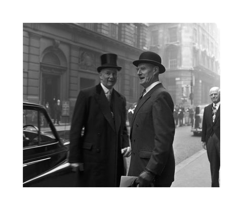 Three formally dressed men on a street flanked by high buildings. c.1955