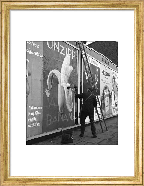 Man pastes up a billboard advertisement. c.1955