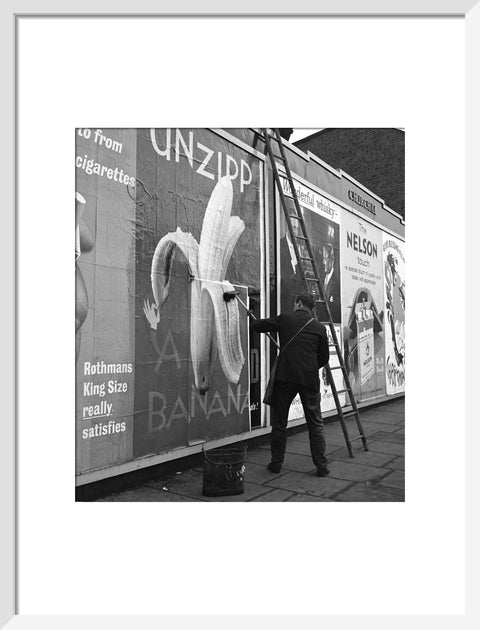 Man pastes up a billboard advertisement. c.1955