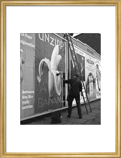 Man pastes up a billboard advertisement. c.1955