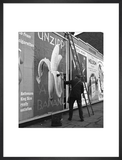 Man pastes up a billboard advertisement. c.1955