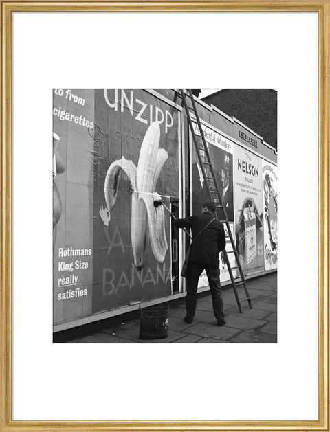 Man pastes up a billboard advertisement. c.1955