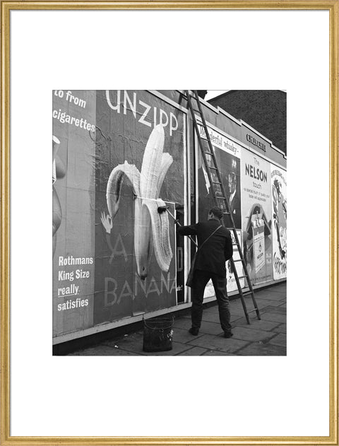 Man pastes up a billboard advertisement. c.1955